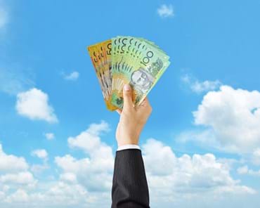 man holding up money proudly towards the sky