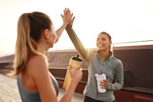 Friends high fiving after exercising and looking after health